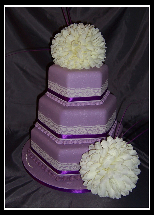 Three tier stacked hexagonal wedding cake with vibrant purple icing