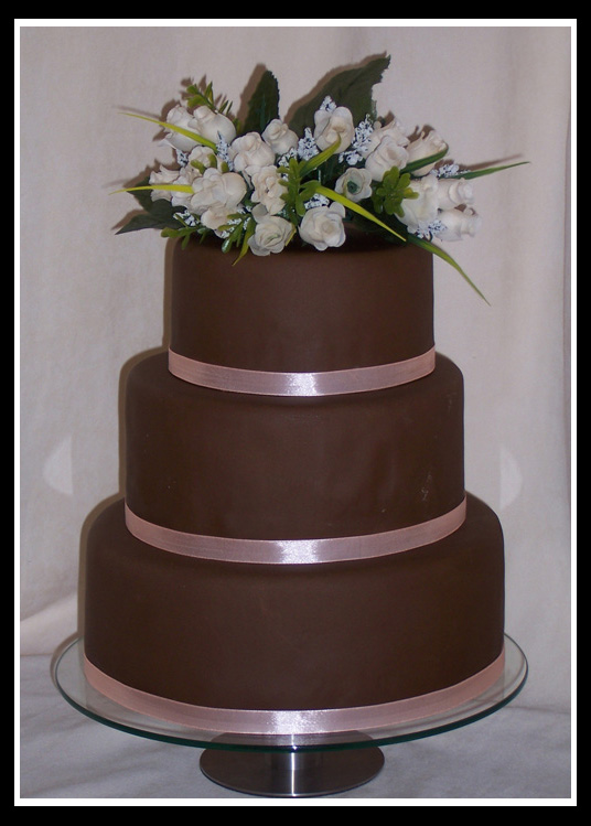 Three tier stacked round chocolate coloured wedding cake