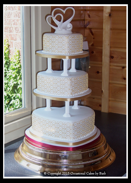 Three tier heart shaped wedding cake on classical pillars